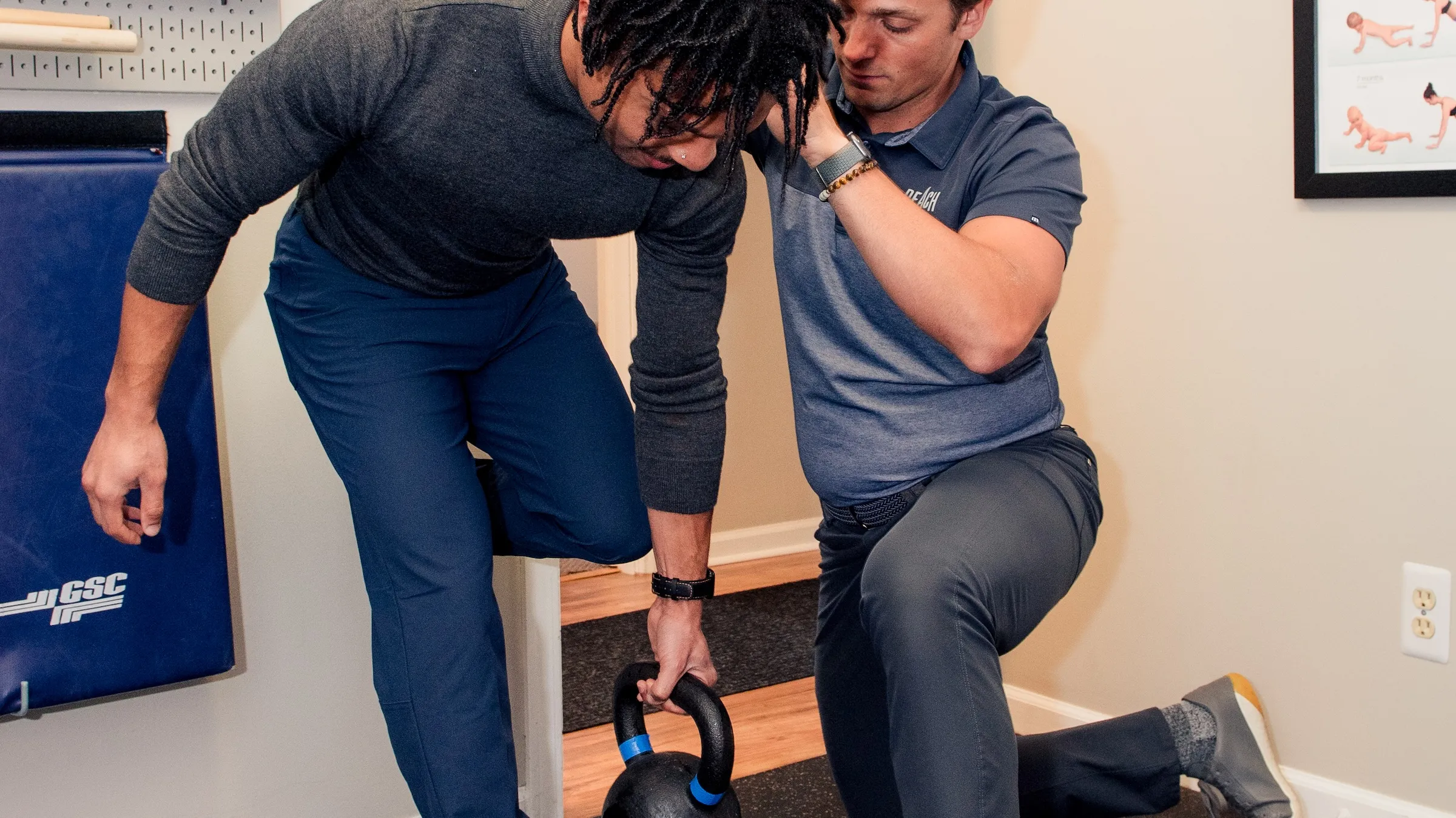 Dr. RJ Burr coaching a patient through a kettlebell deadlift at REACH Rehab + Chiropractic in Plymouth, MI